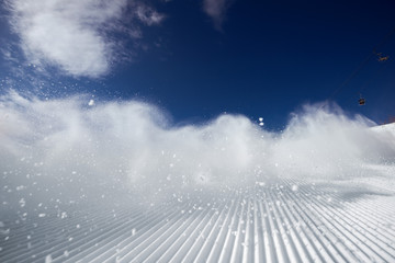 Snow dust cloud after skier or snowboarder on the ski slope. Sheregesh resort, Siberia, Russia.