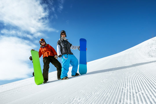 Group of two snowboarders standing on the slope prepared by snowcat. Sheregesh resort, Siberia, Russia