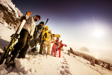 Group of friends skiers and snowboarders standing on the slope on background of valley. Sheregesh...