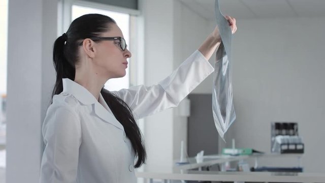 Female doctor radiologist view mri brain scan and speaking smart phone