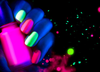 Fluorescent nail polish. Fashion model woman nails in neon light
