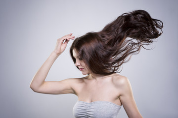 Beautiful young woman with flowing hair in studio