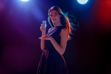 The beautiful girl dancing at the party drinking champagne