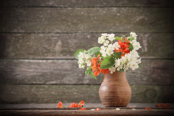 flowers in jug on wooden background