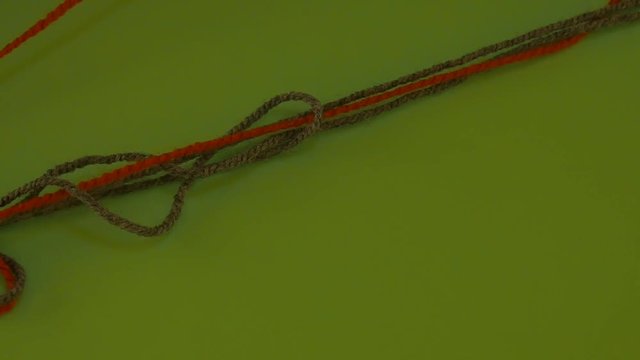 Green and Red Yarn Tangled Threads on Green Screen Colored Wool Someone is Pulling Filament Fiber Threads Are Moving Someone is Pulling the Thread