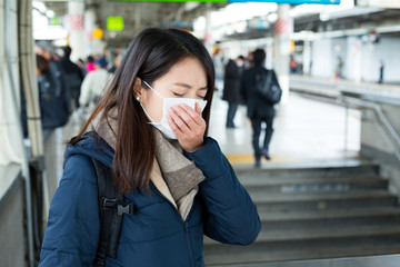 Woman wearing face mask in train station