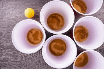 Red plastic cups arranged for playing Beer Pong isolated on wooden background.
