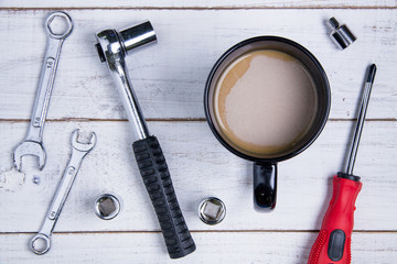 Coffee cup and equipment repair on the white wooden background