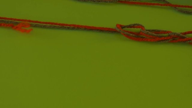 Tangled Threads of Wool on Green Screen Colorful Red and Green Someone is Pulling Filament Fiber Threads Are Moving Someone is Pulling the Thread