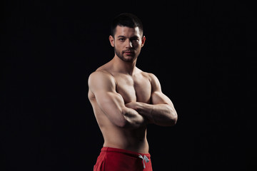Fototapeta na wymiar Handsome bodybuilder standing with arms folded