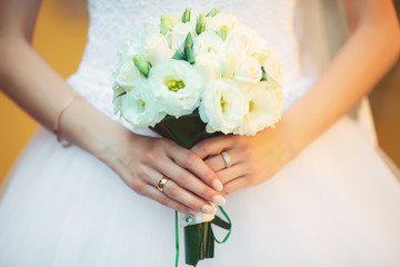 Obraz na płótnie Canvas The bride with a bouquet, close-up on a background of dress
