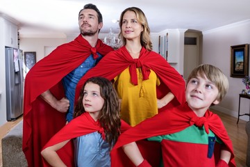 Family pretending to be superhero in living room
