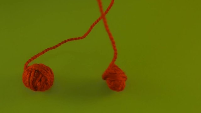 Red Yarn Ball is Unraveling on Green Screen Colorful Tangle of Fiber Someone is Pulling Filament Threads Are Moving Someone is Pulling the Thread