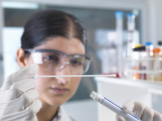 Female scientist extracting DNA sample swab for genetic tests in laboratory