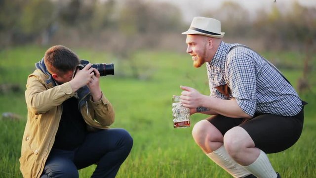 The photographer takes a picture of a man who drinks beer.