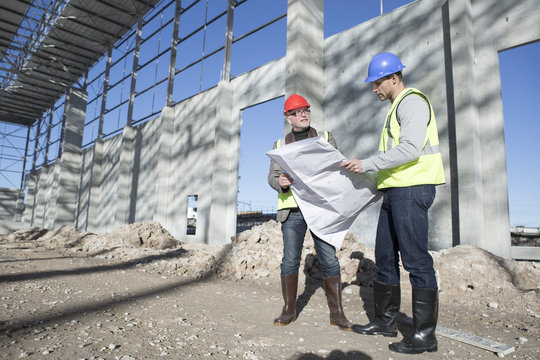 Surveyor and architect meeting on construction site