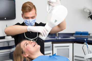 Dentist or radiologist scanning teeth of patient with x-ray apparatus