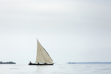 Fototapeta premium Traditional fisherman boat in Zanzibar on ocean with rainy cloud