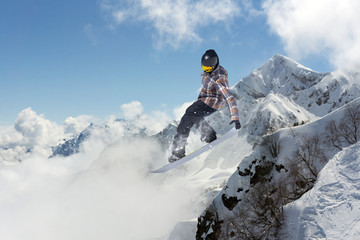 Snowboard rider jumping on mountains. Extreme snowboard freeride sport.