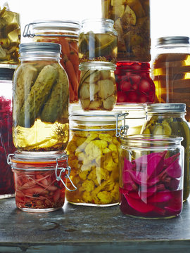 Various pickles in glass jars, close-up
