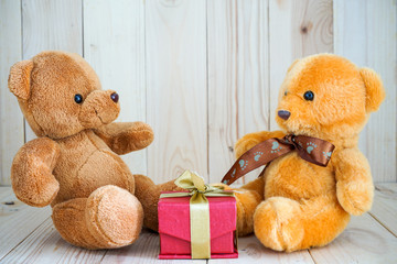 two bear dolls and red gift box on the wood floor, select focus eye