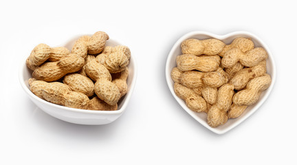 peanuts in a heart shaped bowl, isolated on white