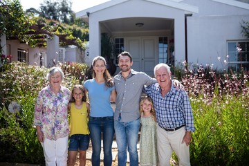 Multi-generation family standing on the garden path