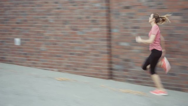 Woman running, sprinting on the sidewalk - interval run
