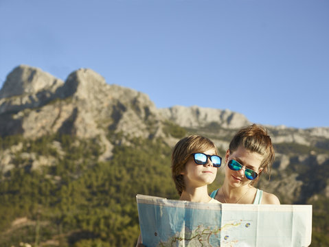 Teenage girl and brother looking at map, Majorca, Spain
