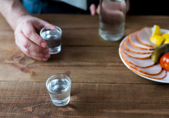 Shot glasses of vodka on a wooden table