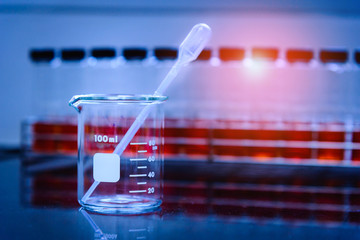 Beaker and blurred many test tube in laboratory. Selective focus