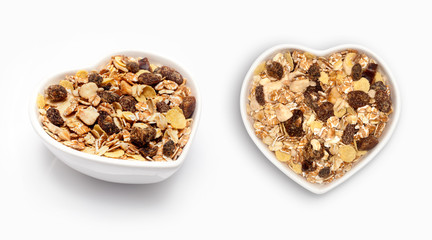Muesli in a heart shaped bowl, isolated on white