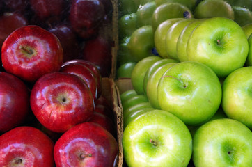Green and red apples stacked in rows with reflective background