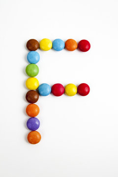 La lettera F formata da coloratissimi confetti di cioccolato.