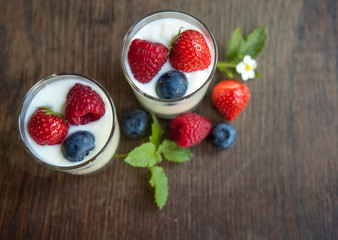 Naturjogurt  mit Frische Beeren  auf Weißen Holz Hintergrund im Tageslicht