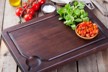 Salsa sauce and ingredients with fresh salad Dark steak cutting bord wooden background Copy space.