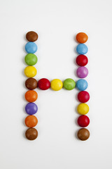 La lettera H formata da coloratissimi confetti di cioccolato.