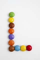 La lettera L formata da coloratissimi confetti di cioccolato.