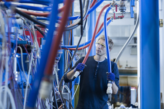 Factory technician inspecting network cables