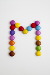 La lettera M formata da coloratissimi confetti di cioccolato.