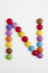 La lettera N formata da coloratissimi confetti di cioccolato.