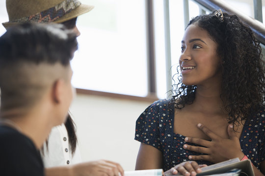 Students on steps, discussing over textbook