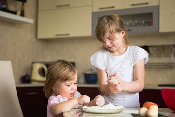 Obraz na płótnie Canvas two children in the kitchen, child 2 years, child 7 years