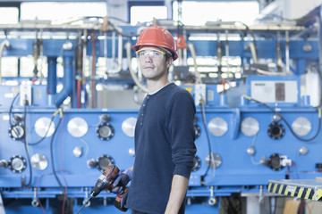 Portrait of factory engineer and industrial machinery