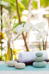Spa and wellness massage setting Still life with candle, towel and stones Outdoor summer background