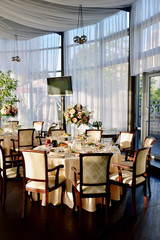 Beautiful wedding restaurant for marriage. White decor for bride and groom. Colorful decoration for celebration. Beauty bridal interior. Bouquet, food and flowers in hall