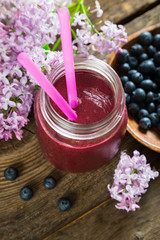 Blueberry smoothie and lilac flowers