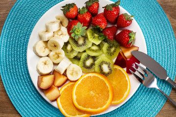 Plato de frutas variadas sobre plato blanco. Vista superior y de cerca
