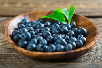 Fresh blueberries in a wooden plate