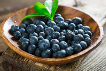 Fresh blueberries in a wooden plate